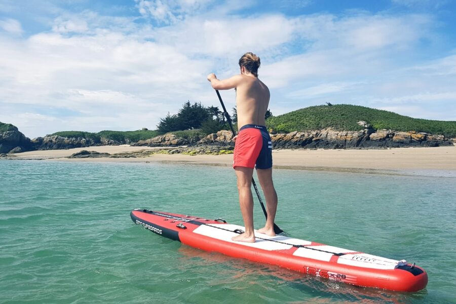 Jeune breton qui fait du paddle en bord de mer