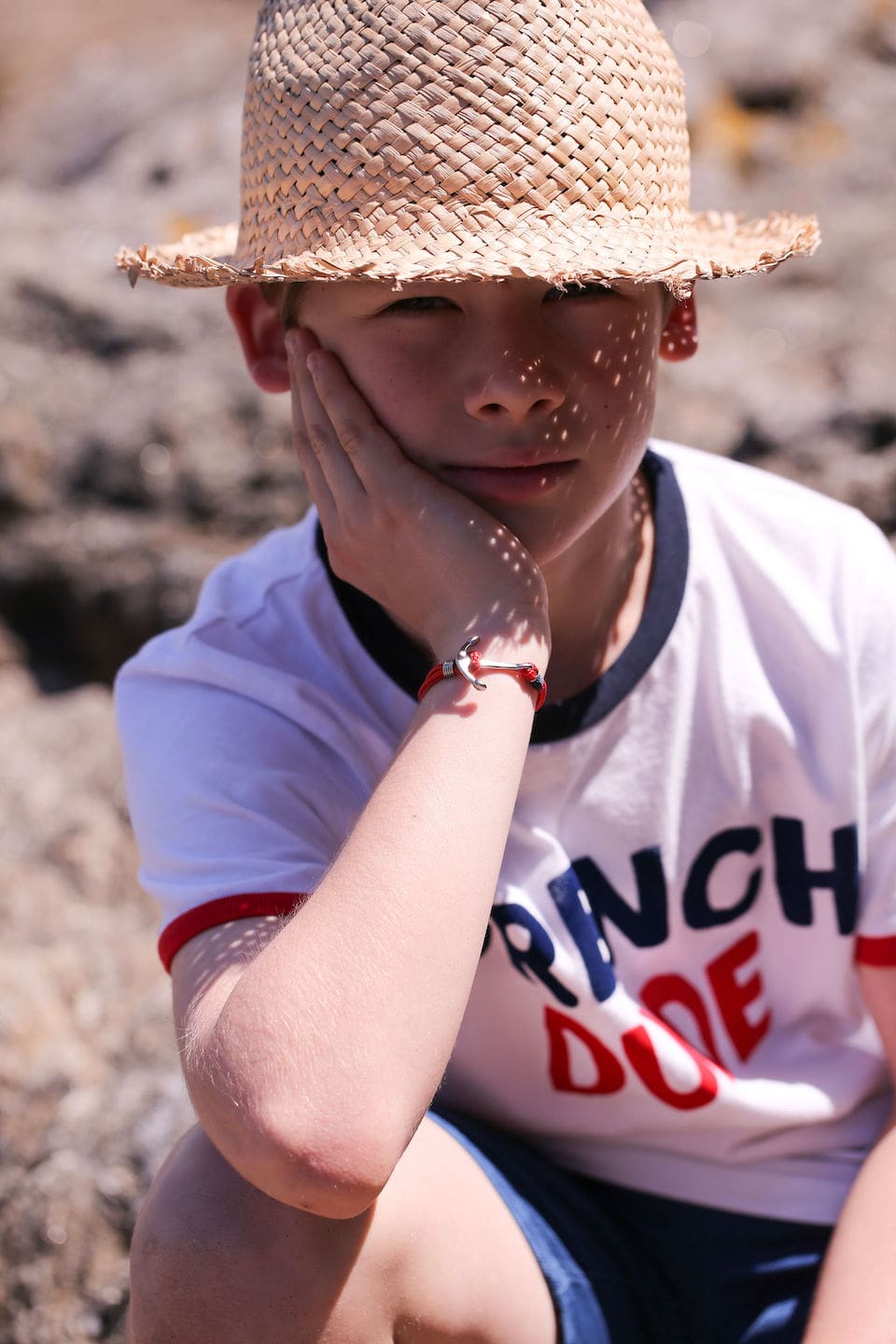 Enfant avec un chapeau de paille qui profite de l'été à la plage