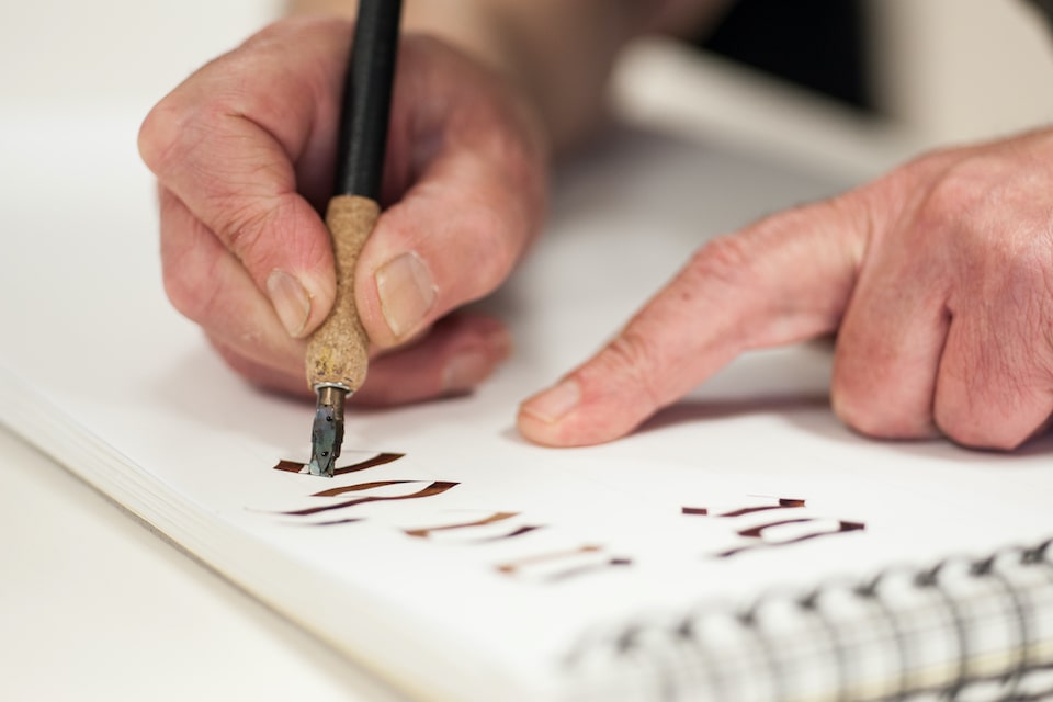 Homme qui fait de la calligraphie en breton