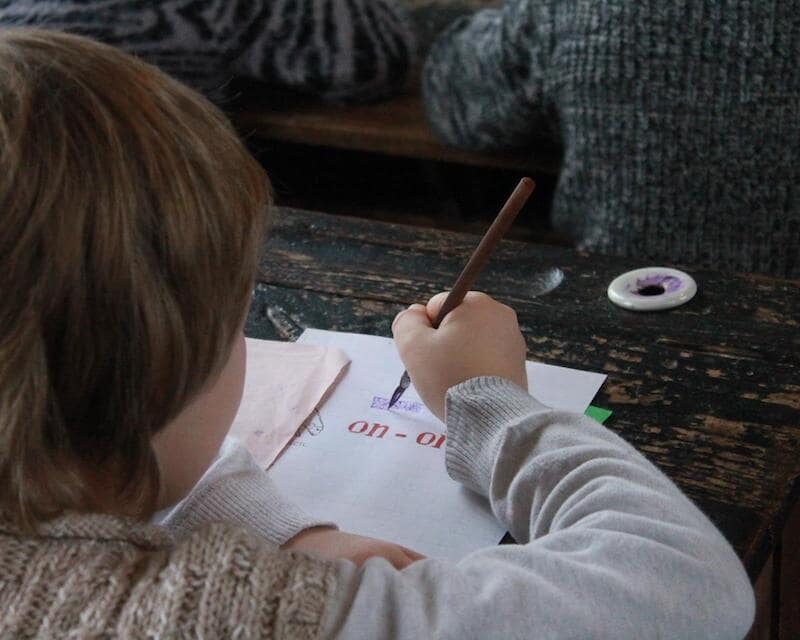 Enfant qui écrit avec un porte-plume