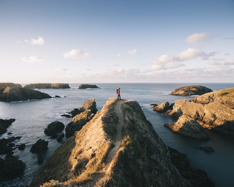 Homme au sommet des aiguilles de Port Coton dans le Morbihan