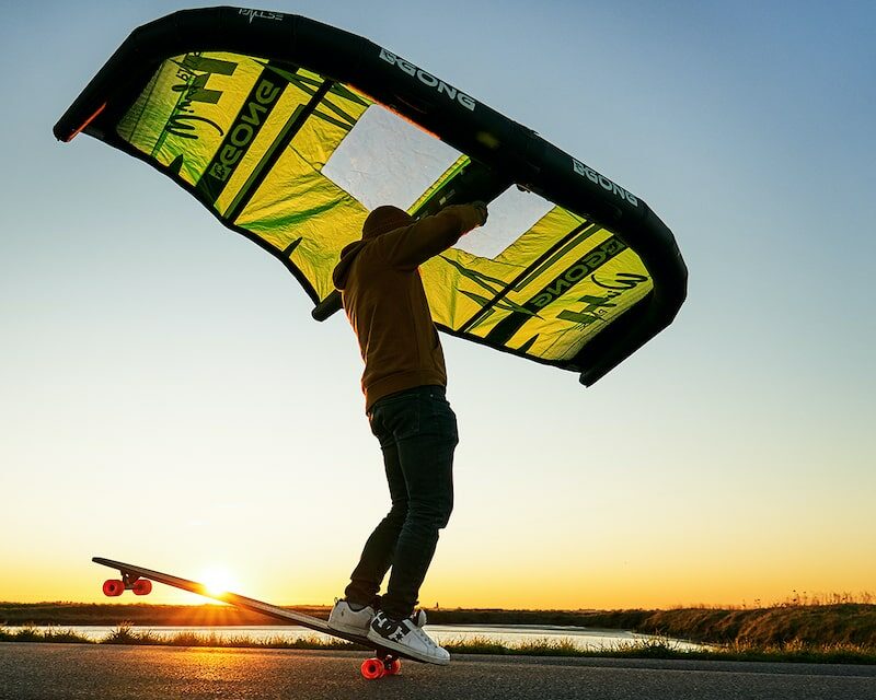 Homme qui fait du skate avec une aile