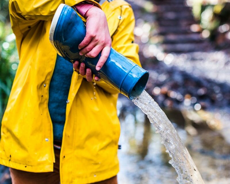 Enfant qui vide sa botte de pluie