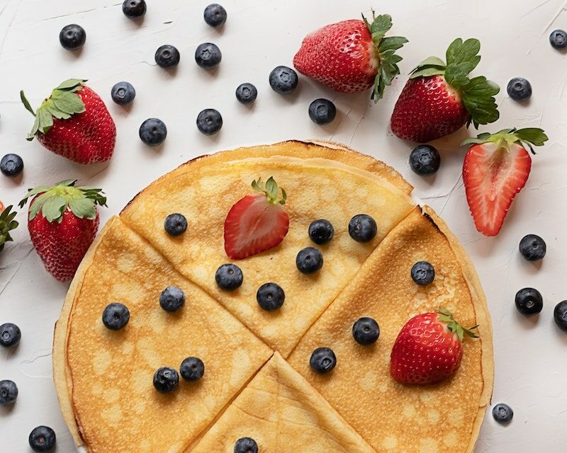 Une assiette de crêpes avec des fruits rouges