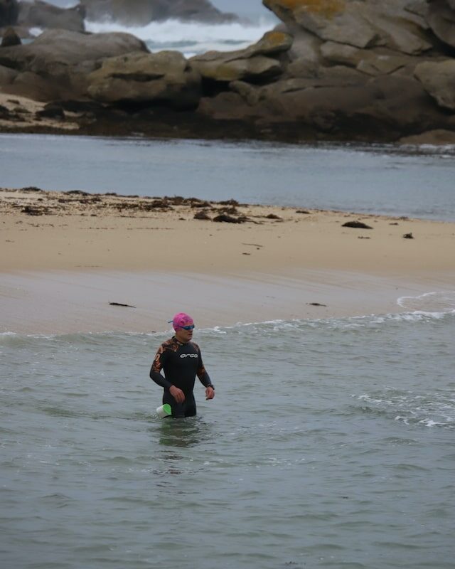 Un nageur en combinaison qui entre dans la mer