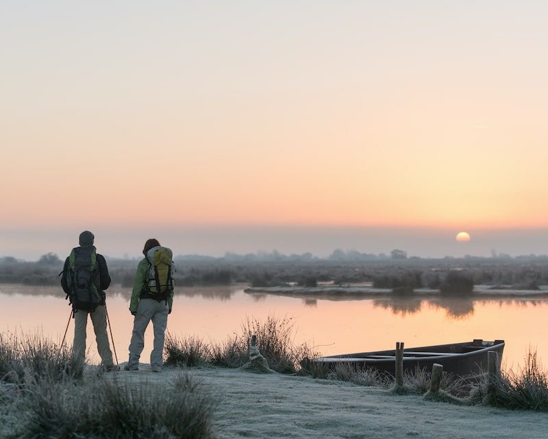 Deux personnes qui contemplent la Brière au petit matin en hiver