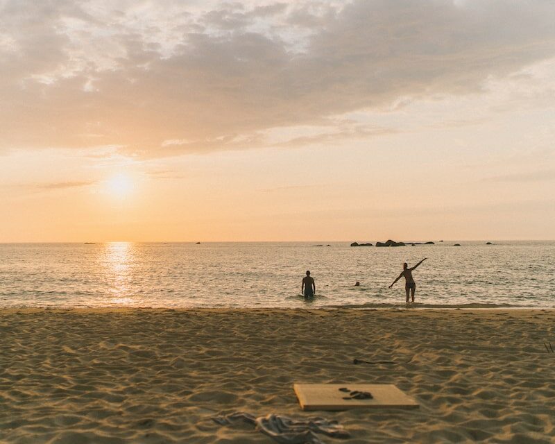 Un couple qui va se baigner pendant le coucher de soleil