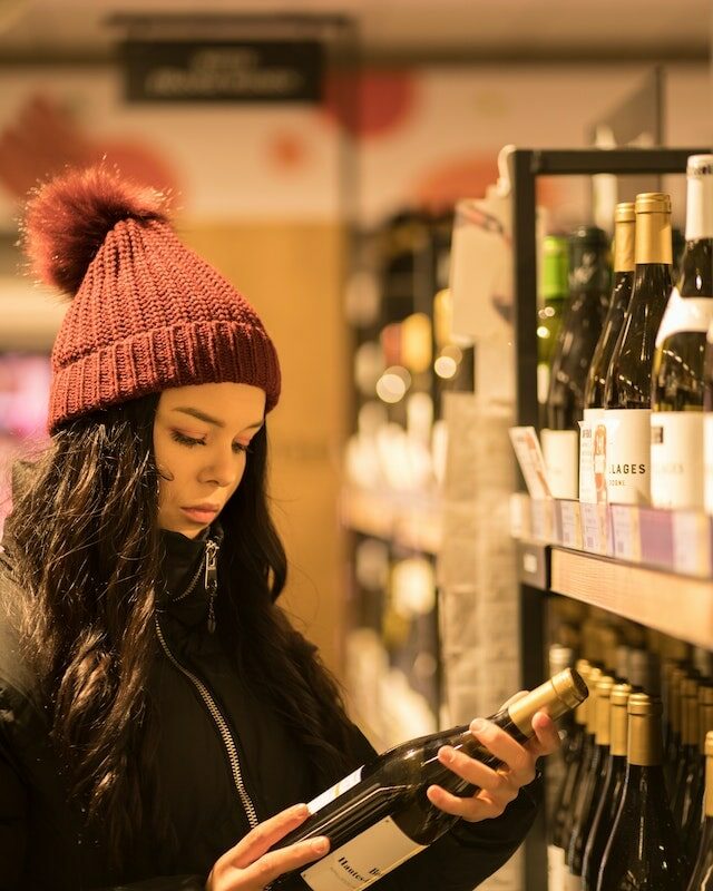 Femme qui choisit une bouteille de vin