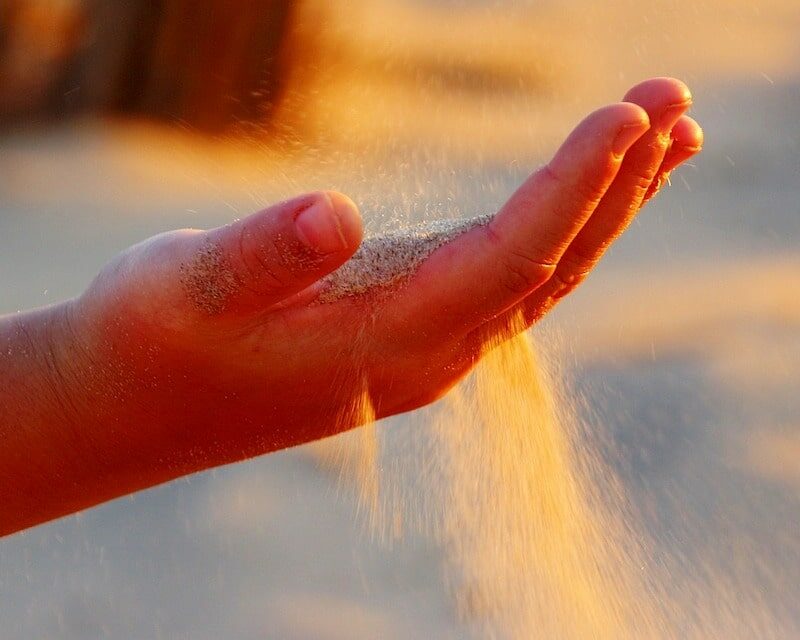 Une main qui laisse filer le sable