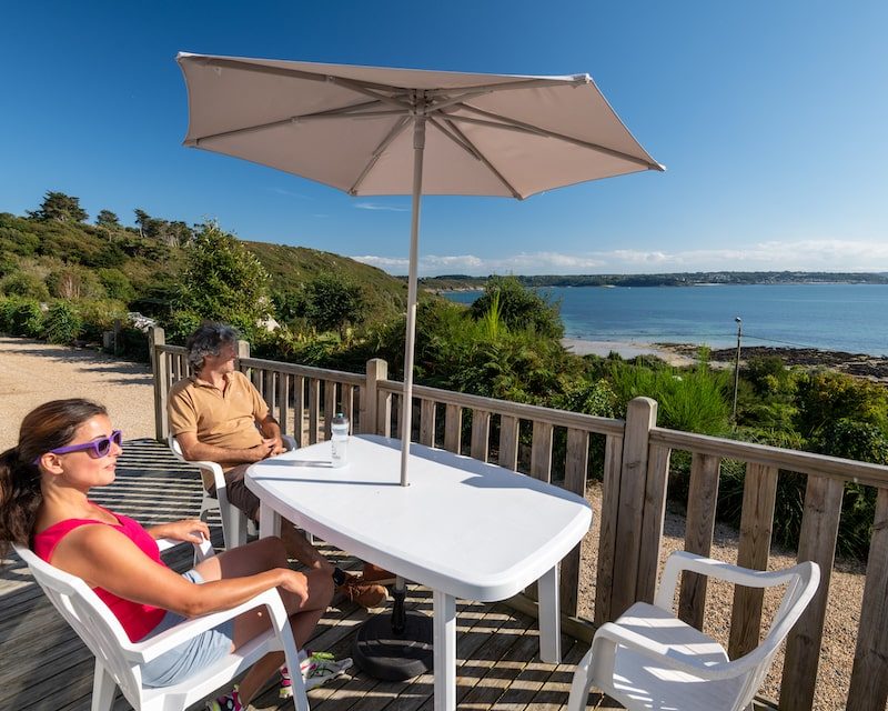 Un couple en face de la mer sur une table de camping